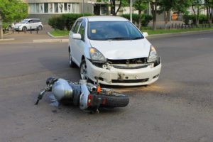 Motorcycle Accident Lawyer Richmond, VA accident involving a white car and motorcycle on the ground. 