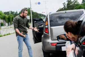 Discussing The Dangers Of Tailgating - rear end accident scene upset driver exclaiming at sight of damage