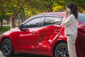 A woman on the phone after a car crash, wondering how long a car accident settlement takes.