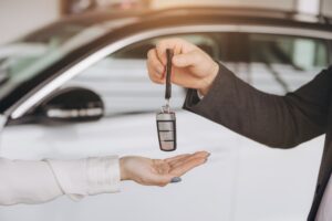 A car accident victim getting the keys to a rental car, that the inusrance is paying for.
