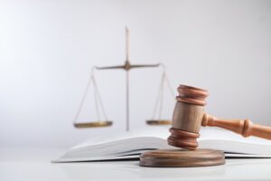 A gavel on a table in front of the scales of justice. How do personal injury settlements work?